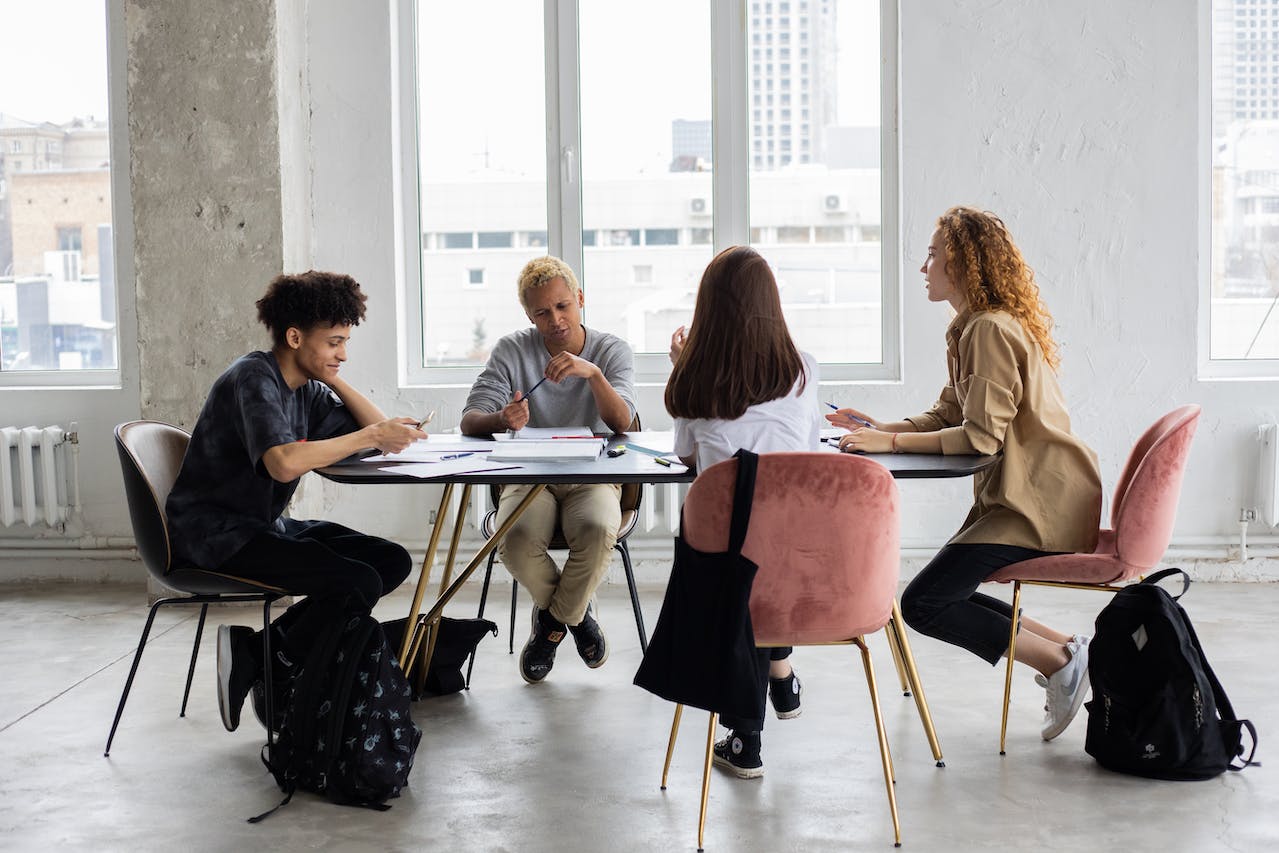 diverse individuen die hun levensproject aan tafel bespreken