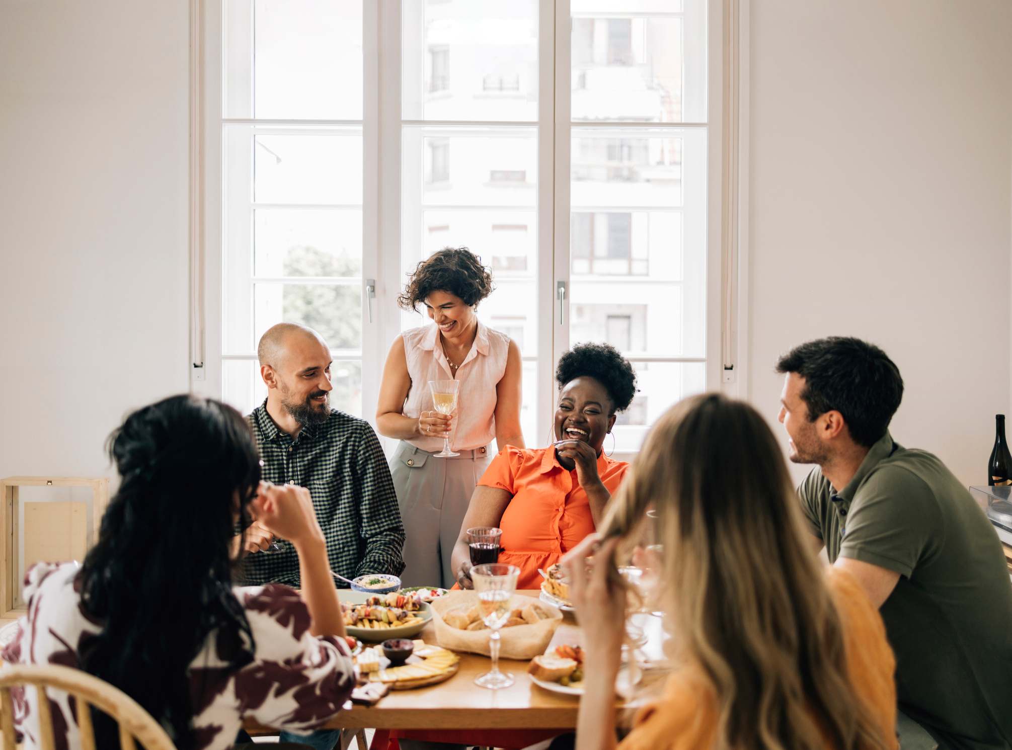 Groep vrienden die tijdens de lunch praten en lachen, hoe ze hun zelfbeschikking kunnen verbeteren