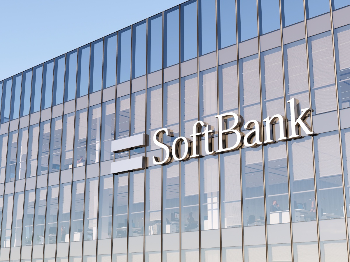 The SoftBank logo on a glass building against a blue sky.